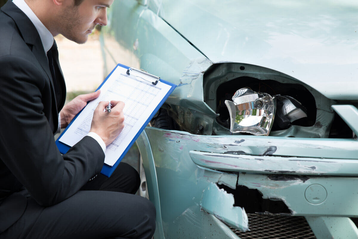 Un inspector de asigurari verifica daunele la o masina avariata in accident