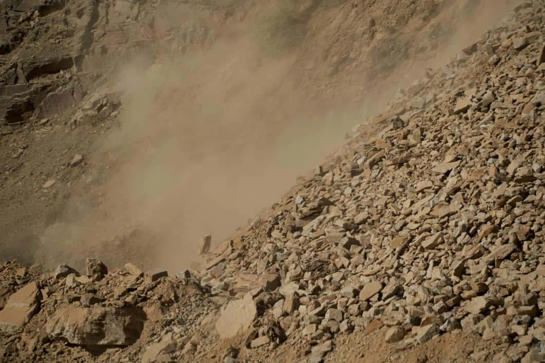 Pante stancoase acoperite cu bolovani si praf indicand miscarea recenta a terenului instabil