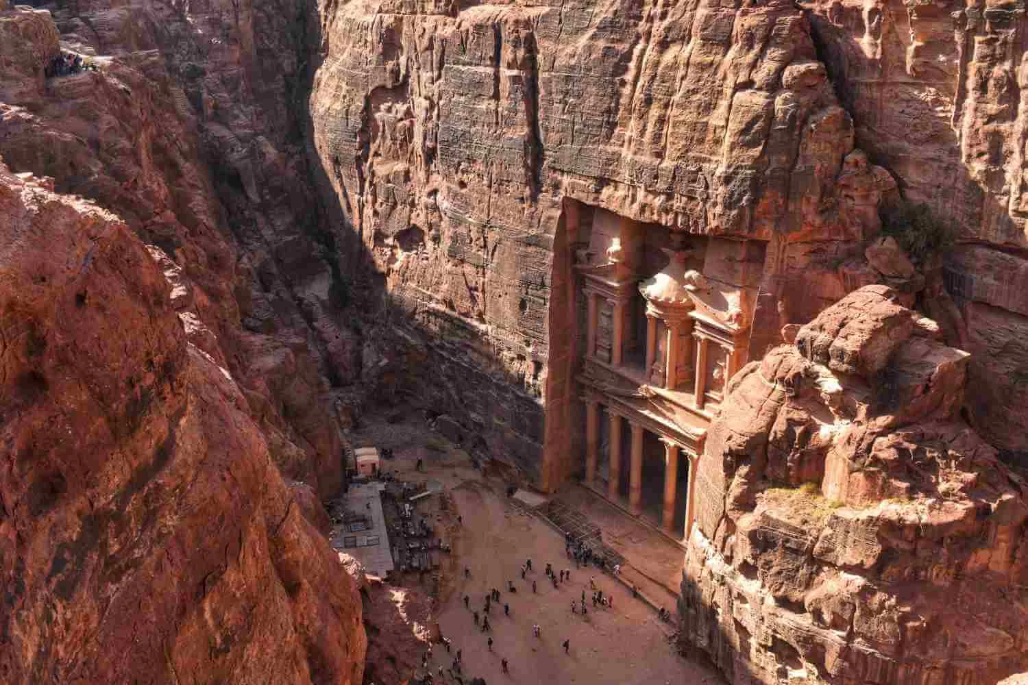 Fatada monumentului Al Khazneh din petra sculptata in stanca inconjurata de pereti abrupti