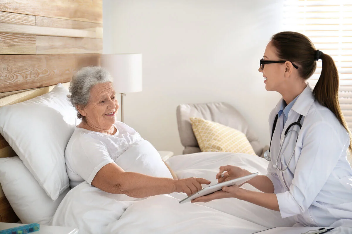 Cadru medical viziteaza o pacienta la pat