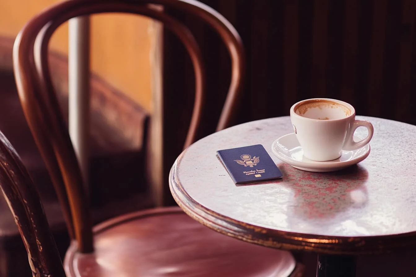 Pașaport și ceașcă de cafea pe o masă de cafenea