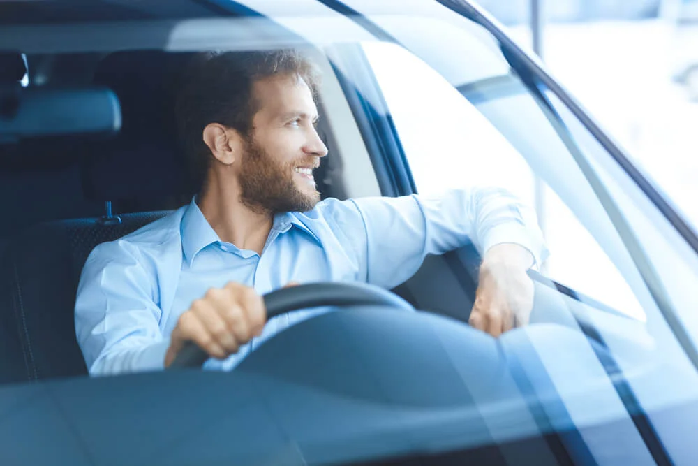 Sofer la volan care se uita pe geam